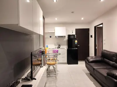 a kitchen and living room with a couch and a table at Chalong Bay - One bedroom on 7 Floor at Tower 1 in Ban Klang