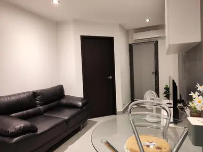 a living room with a couch and a glass table at Chalong Bay - One bedroom on 7 Floor at Tower 1 in Ban Klang