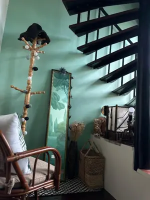 a room with a mirror and a chair and stairs at Village 40 Phuket Old Town in Phuket Town