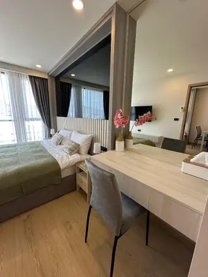 a bedroom with a large bed and a wooden table at The Ozone Condominium 514 one bedroom in Laguna Phuket