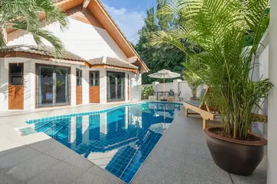 a swimming pool next to a house at Naiharn Beach Holiday Pool Villa, Rawai in Rawai Beach