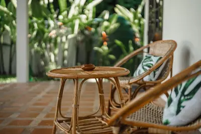 a small wooden table sitting next to two chairs at Naiharn Beach Holiday Pool Villa, Rawai in Rawai Beach