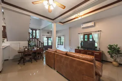 a living room with a couch and a television at Naiharn Beach Holiday Pool Villa, Rawai in Rawai Beach
