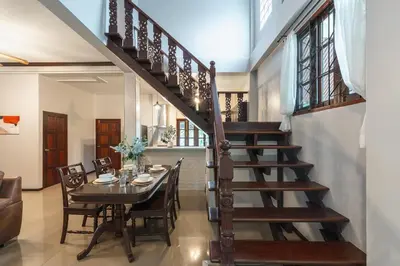 a dining room with a table and a staircase at Naiharn Beach Holiday Pool Villa, Rawai in Rawai Beach