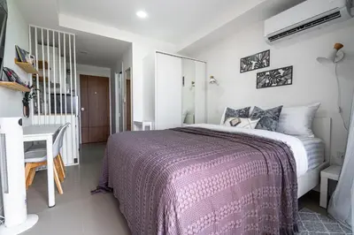 a bedroom with a large bed and a desk at North Gate Apartments in Ban Mai Salae