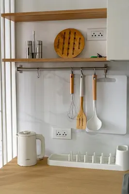 a kitchen with wooden utensils on a shelf at North Gate Apartments in Ban Mai Salae