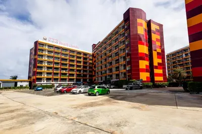 a large building with cars parked in a parking lot at North Gate Apartments in Ban Mai Salae