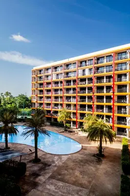 a large apartment building with a swimming pool and palm trees at North Gate Apartments in Ban Mai Salae