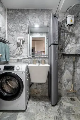a bathroom with a washing machine and a sink at North Gate Apartments in Ban Mai Salae