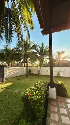 a house with palm trees and a garden with flowers at Phuket Cozy Villa Pasak4 Green Garden BangTao in Laguna Phuket