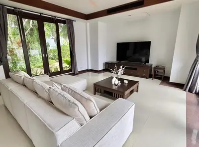 a living room with a white couch and a television at Phuket Cozy Villa Pasak4 Green Garden BangTao in Laguna Phuket
