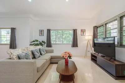 a living room with a couch and a tv at Naiharn Beach Holiday Villa, Rawai Phuket in Rawai Beach