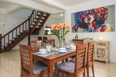 a dining room with a table with chairs and a painting at Naiharn Beach Holiday Villa, Rawai Phuket in Rawai Beach