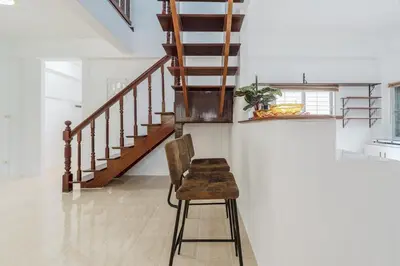 a chair in a room with a staircase at Naiharn Beach Holiday Villa, Rawai Phuket in Rawai Beach