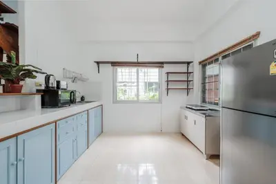 a kitchen with blue cabinets and a refrigerator at Naiharn Beach Holiday Villa, Rawai Phuket in Rawai Beach