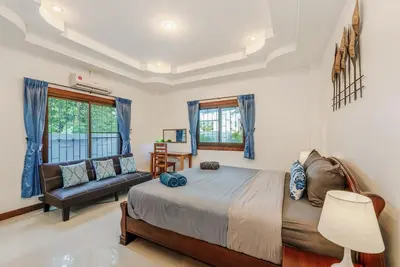 a bedroom with a bed and a couch at Family Sea View Holiday Pool Villa, Saiyuan Phuket in Ban Saiyuan (1)