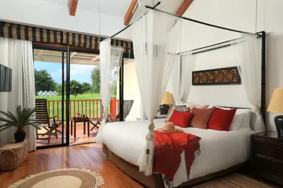 a bedroom with a large white bed with red pillows at Laguna Golf View Pool Villa in Ban Thalat Choeng Thale