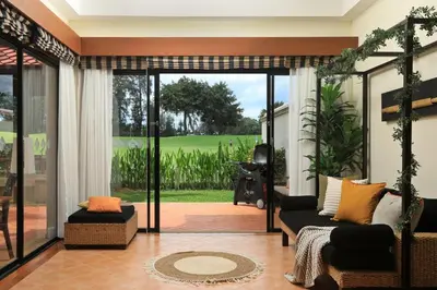 a living room with a couch and a large glass door at Laguna Golf View Pool Villa in Ban Thalat Choeng Thale