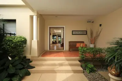 a hallway of a building with a couch and plants at Laguna Golf View Pool Villa in Ban Thalat Choeng Thale