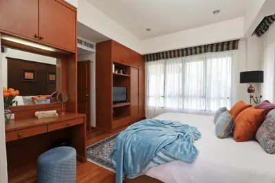 a bedroom with a bed and a desk and a television at Laguna Golf View Pool Villa in Ban Thalat Choeng Thale