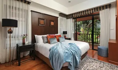 a bedroom with a large bed and a balcony at Laguna Golf View Pool Villa in Ban Thalat Choeng Thale