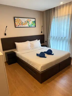 a bedroom with a bed with two blue towels on it at Title 5 in Rawai Beach