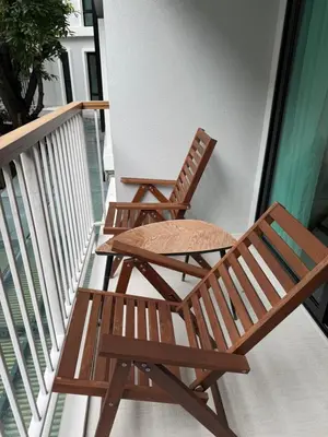 two wooden chairs sitting on a balcony at Title 5 in Rawai Beach