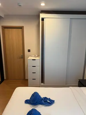 a bedroom with a bed with two blue towels on it at Title 5 in Rawai Beach