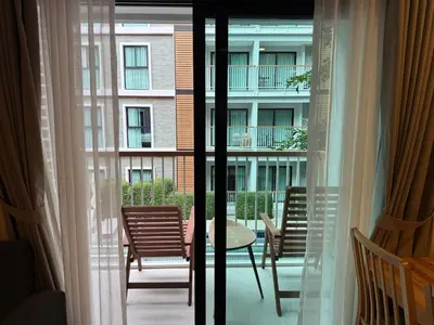 a balcony with a table and chairs and a building at Title 5 in Rawai Beach