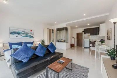 a living room and kitchen with a couch and a table at Chic Condo by Bcare - Purple Rose in Karon Beach
