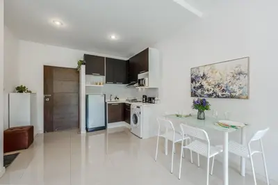 a kitchen and dining room with a table and chairs at Chic Condo by Bcare - Purple Rose in Karon Beach