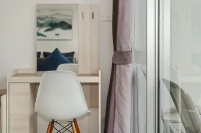 a white chair sitting next to a desk with a mirror at Chic Condo by Bcare - Purple Rose in Karon Beach