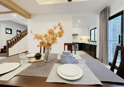 a dining room with a table with plates on it at 3 Bedroom Renovated Villa 3 minutes to the beach in Karon Beach
