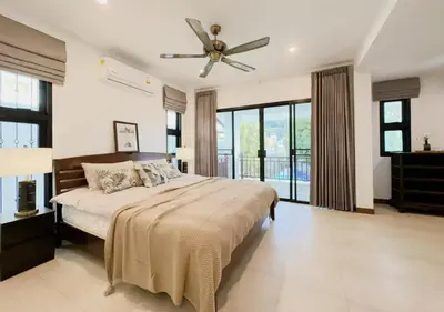 a bedroom with a bed and a ceiling fan at 3 Bedroom Renovated Villa 3 minutes to the beach in Karon Beach