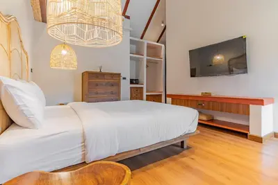 a bedroom with a large white bed and a tv at Private Designer Villa with Pool Prime Rawai 3 beds in Ban Saiyuan (1)