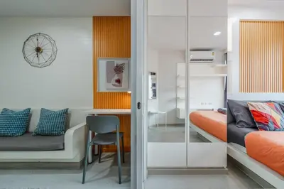 a bedroom with a bed and a desk and a chair at A Stylish Condo in Local Area Kathu, Phuket in Kathu