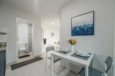 a white dining room with a table and chairs at A Stylish Condo in Local Area Kathu, Phuket in Kathu