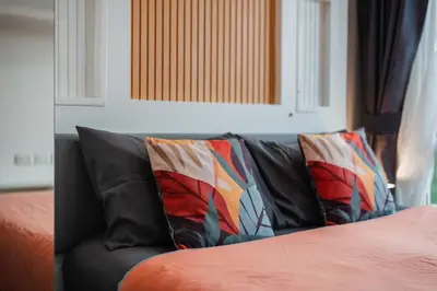 a black couch with two pillows on a bed at A Stylish Condo in Local Area Kathu, Phuket in Kathu