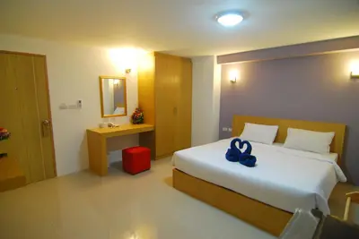a bedroom with a bed with a blue bow on it at Leelawadee Naka in Phuket Town