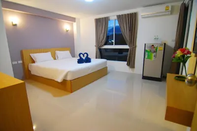 a bedroom with a bed with a blue bow on it at Leelawadee Naka in Phuket Town