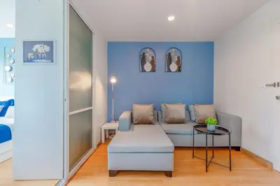 a living room with a couch and a blue wall at A Nice Condo in Local Livelyhood of Kathu in Kathu