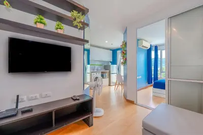 a living room with a flat screen tv on a wall at A Nice Condo in Local Livelyhood of Kathu in Kathu