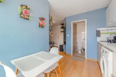 a kitchen with blue walls and a white table and chairs at A Nice Condo in Local Livelyhood of Kathu in Kathu