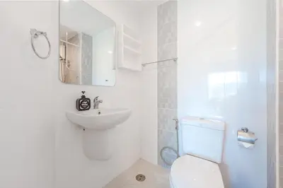 a white bathroom with a sink and a toilet at A Nice Condo in Local Livelyhood of Kathu in Kathu