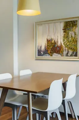 a dining room table with white chairs and a painting at D401 Title Rawai Beach Front 2 Bedroom Apartment in Rawai Beach