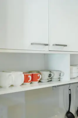 a row of cups on a shelf in a kitchen at D401 Title Rawai Beach Front 2 Bedroom Apartment in Rawai Beach