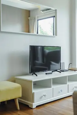 a living room with a tv on a white dresser at D401 Title Rawai Beach Front 2 Bedroom Apartment in Rawai Beach