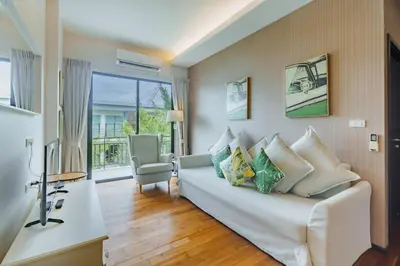 a living room with a white couch with pillows at D401 Title Rawai Beach Front 2 Bedroom Apartment in Rawai Beach