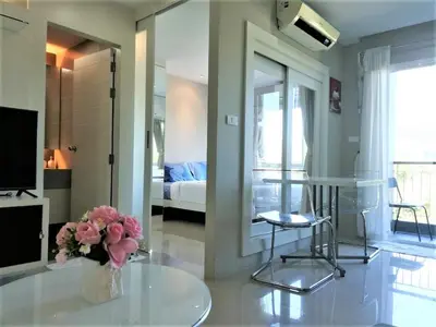 a living room with a vase of flowers on a table at A Fully Furnished Condo in the Phuket Center in Ban Ket Ho