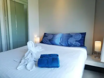 a bed with a stuffed animal and towels on it at A Fully Furnished Condo in the Phuket Center in Ban Ket Ho